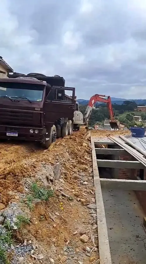 Movimentação de terra com caminhões caçamba e escavadeira em obra na região de Curitiba